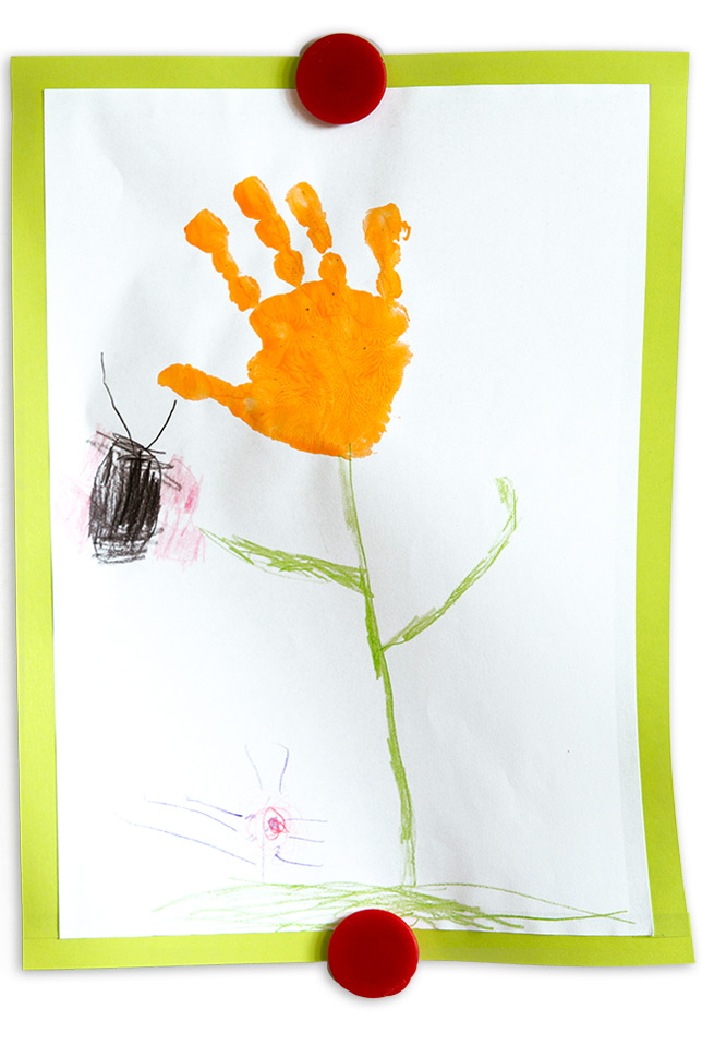 Kinderzeichnung mit einem Handabdruck aus gelber Wasserfarbe